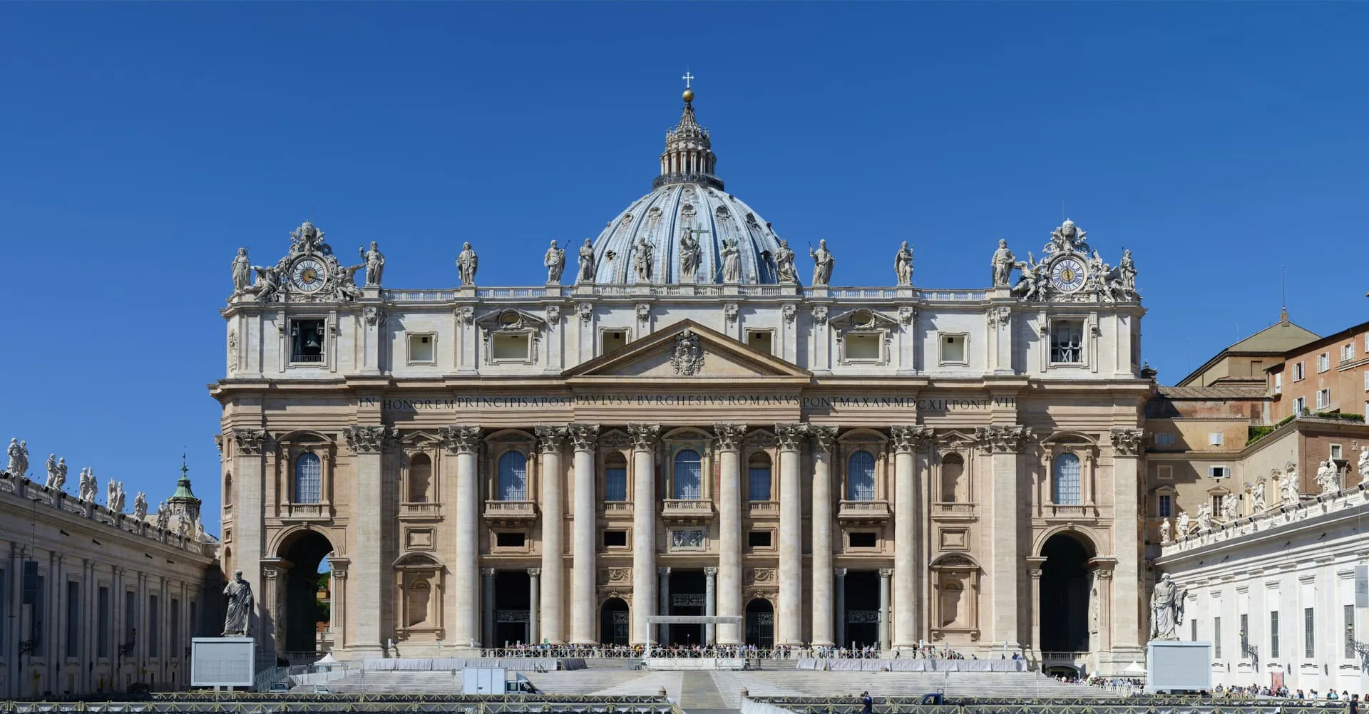 St. Peter's Basilica and Bernini's colonnade under a clear Vatican sky.
